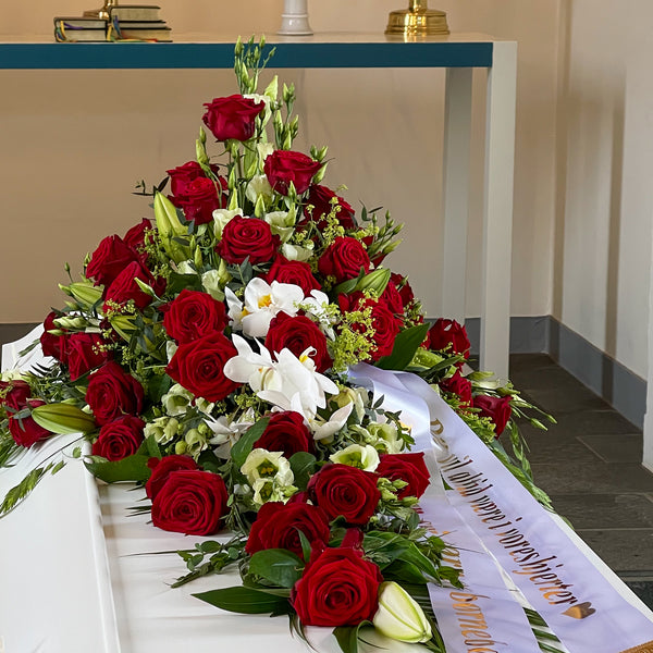 Kistepynt med røde roser og hvide nuancer