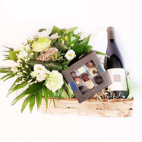 Den blomsterne kurv med vin og chokolade